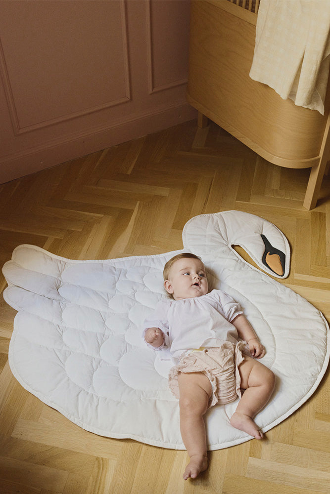 Baby Lying on Warm White Swan Play Mat 