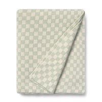 Folded checkered blanket with light blue sage green and white pattern 