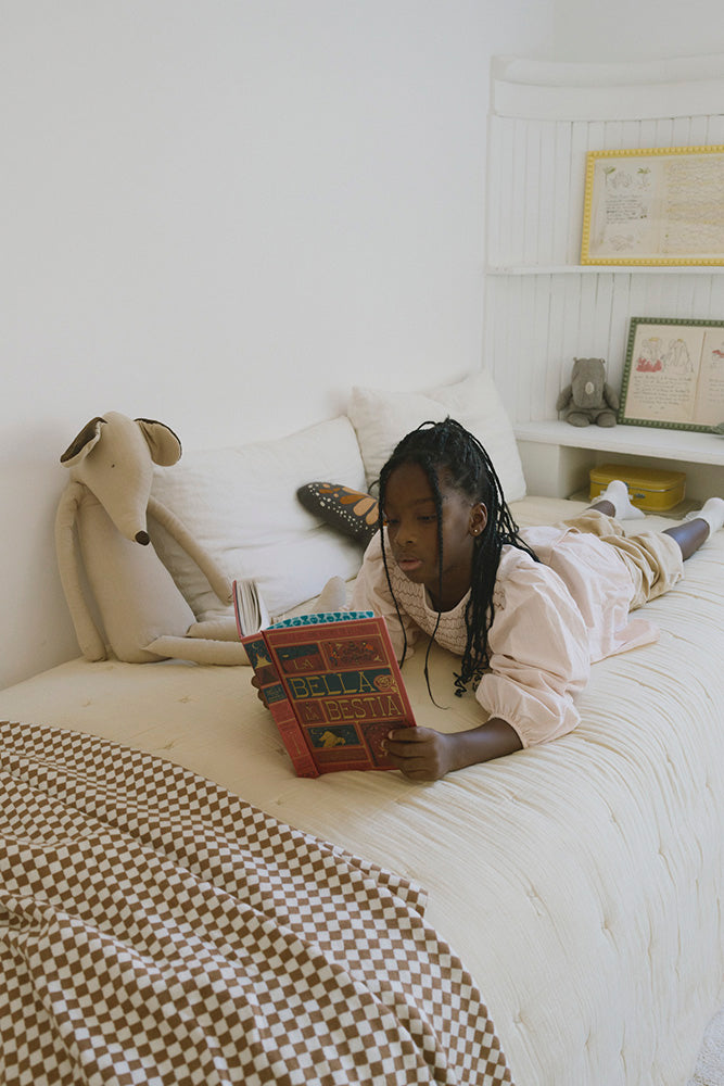 Checked Brown Throw Blanket with Child reading a book on a bed in a cozy bedroom