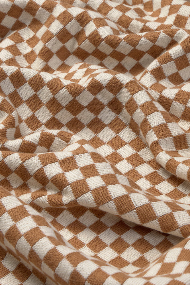 Close-up of brown and white checkered throw blanket