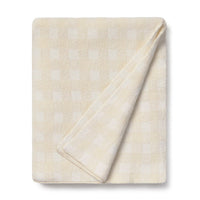 Folded beige and ivory blanket with subtle pattern 