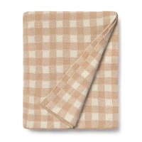 Folded rose and white checkered blanket on a white background
