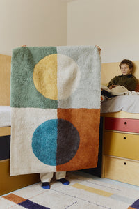 Multicolored geometric rug with circular pattern inspired by Bauhaus