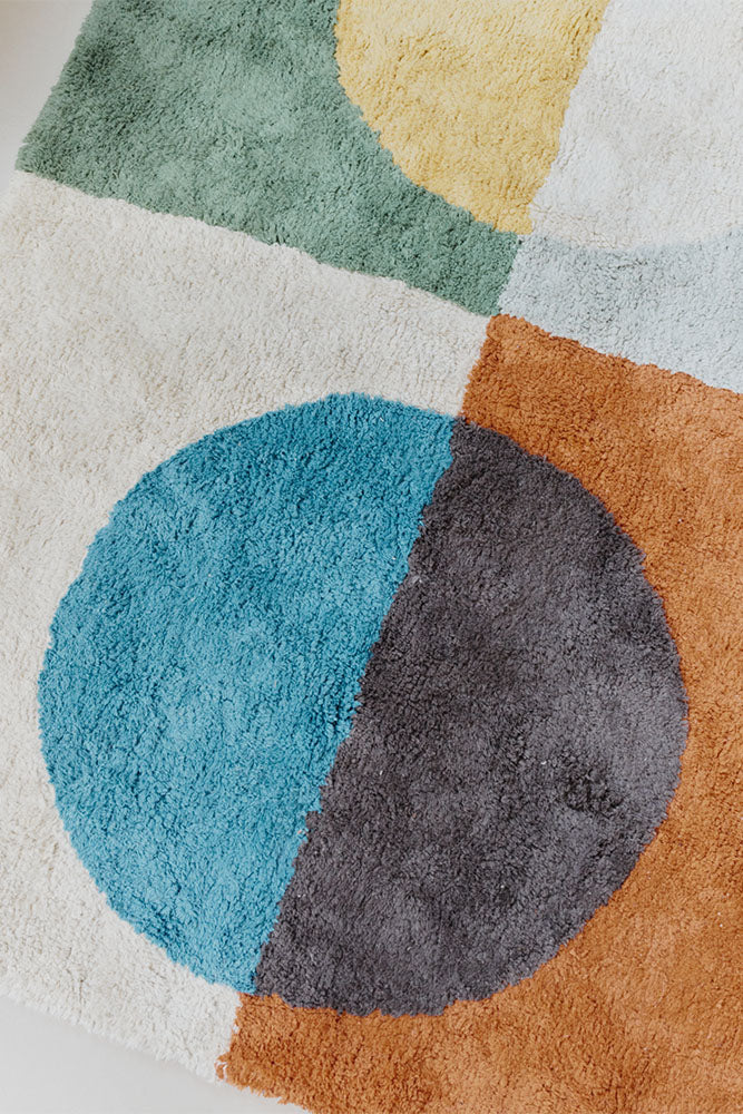 Close up of multicolored geometric rug with circular pattern inspired by Bauhaus
