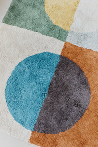 Close up of multicolored geometric rug with circular pattern inspired by Bauhaus