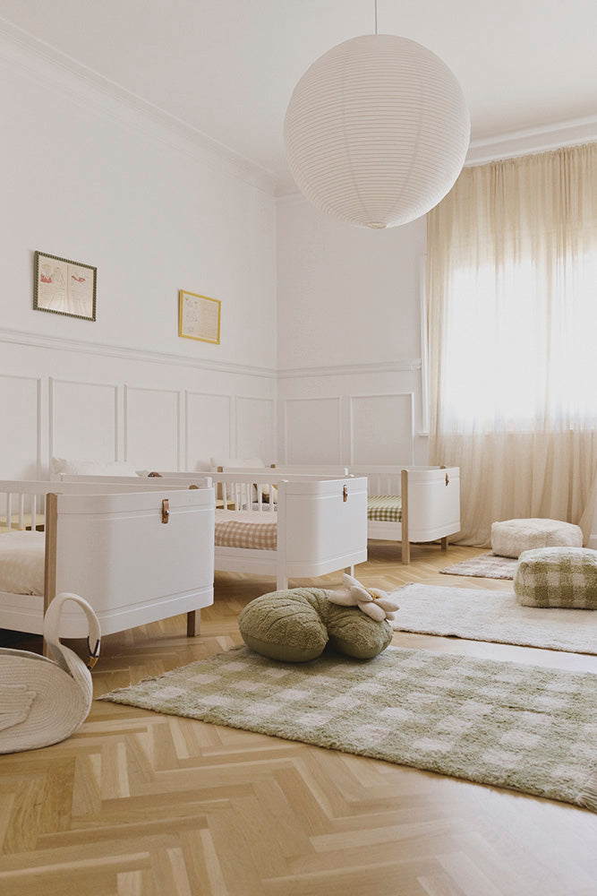 Toddler Beds in Room with Checkered Rugs, Blankets and Poufs
