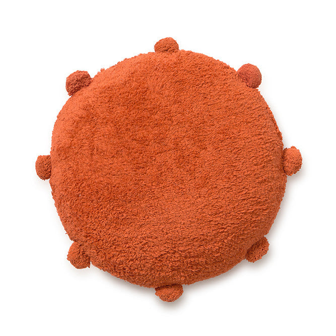 Round orange floor cushion edged with pom-poms